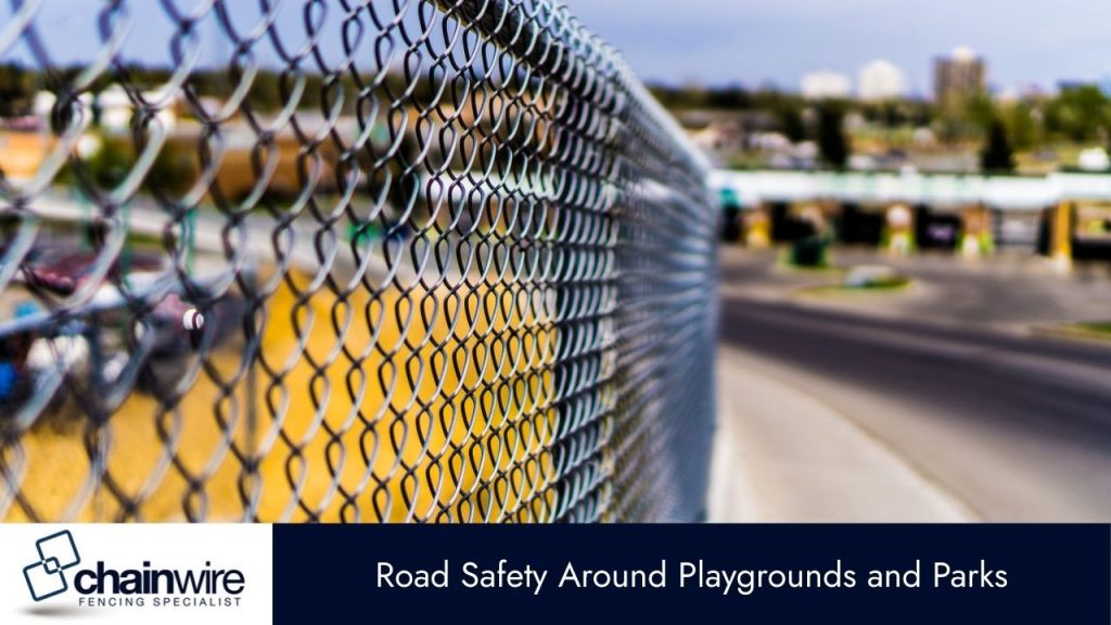 A long chain-link fence stretches into the background, bordering a paved road on the right.