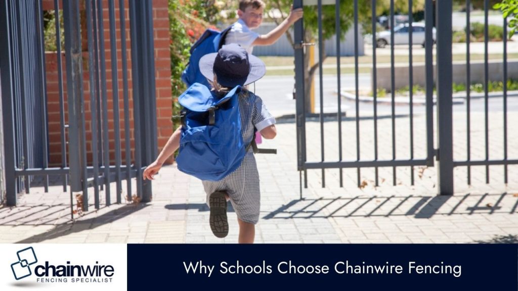 A boy and a girl in school uniforms with backpacks are running through a black metal gate.