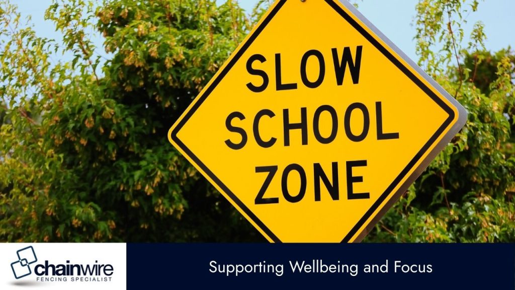 A close-up of a yellow diamond-shaped sign that reads "SLOW SCHOOL ZONE" in black capital letters. 