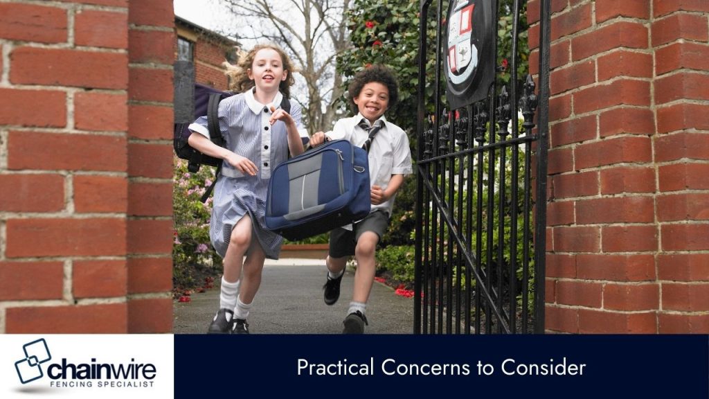 A boy and a girl in school uniforms, carrying a large bag, are running out of a brick and metal fence gateway. 