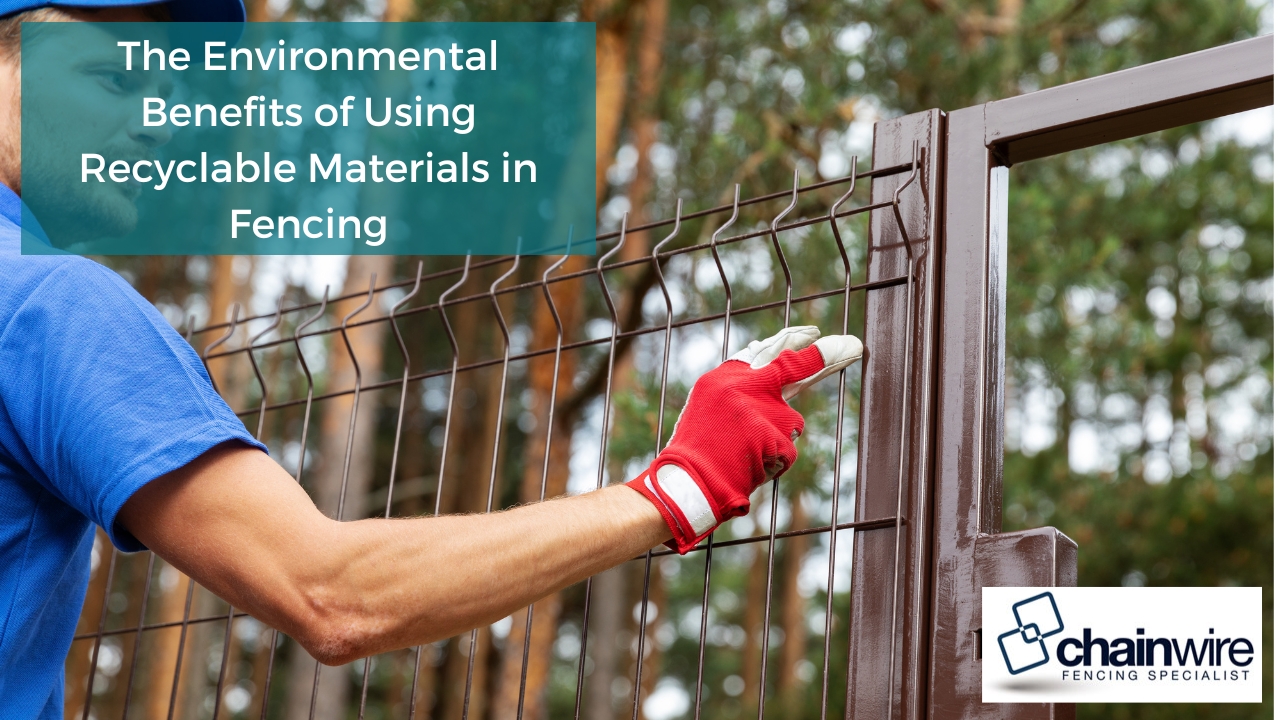 Worker installing a metal fence outdoors with gloved hands. The image highlights the environmental benefits of using recyclable materials in fencing